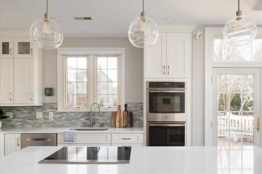 Open-plan kitchen with a large island looking through a cased opening into a bay-window breakfast area and family room