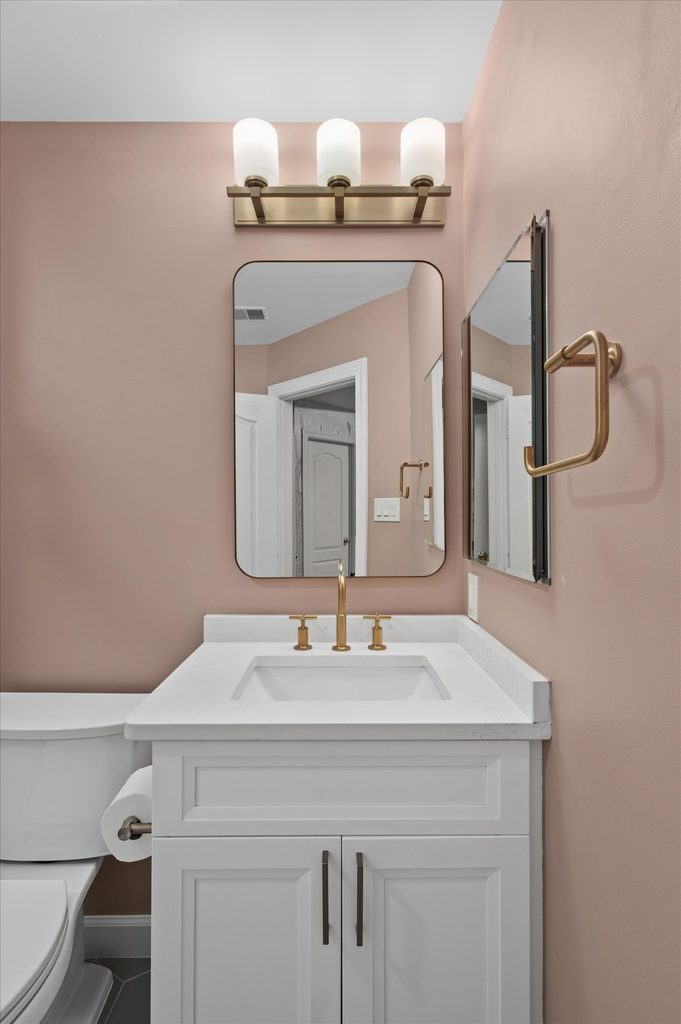 Frost-painted bathroom vanity with a marble-look counter and honey bronze pulls
