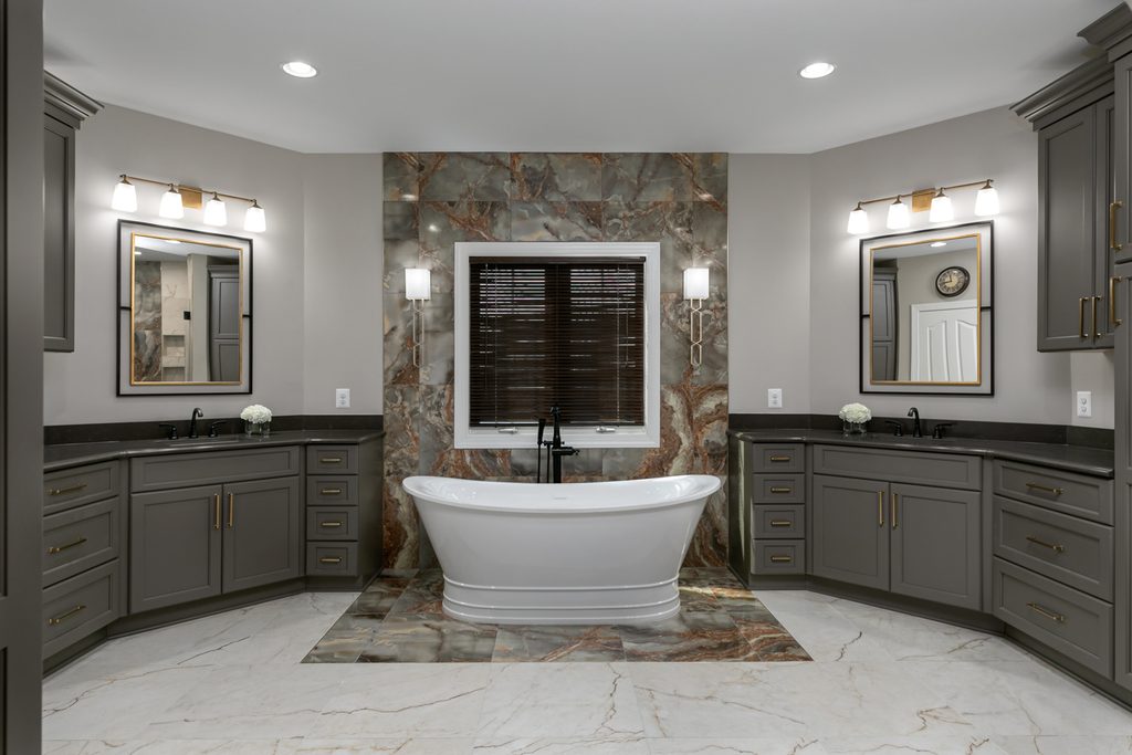 Freestanding soaking tub with a matte black floor-mounted tub filler centered on a jade porcelain accent wall