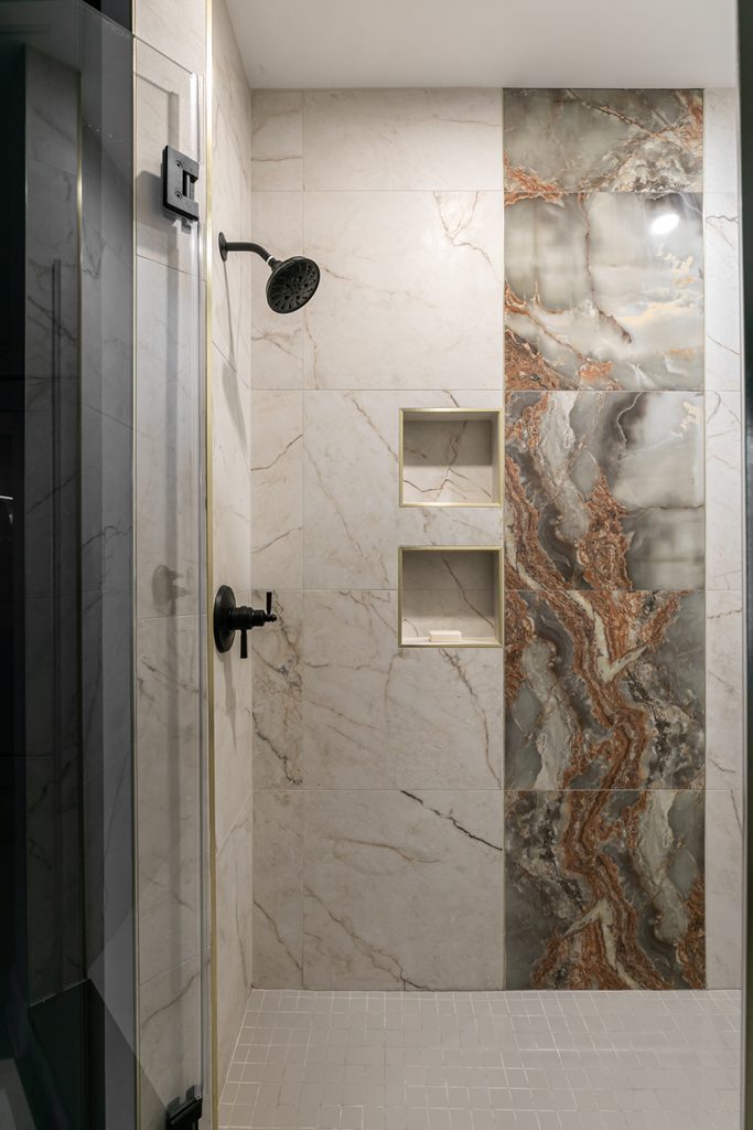 Soft gray flat-panel double vanity with bronze pulls and a polished quartz counter