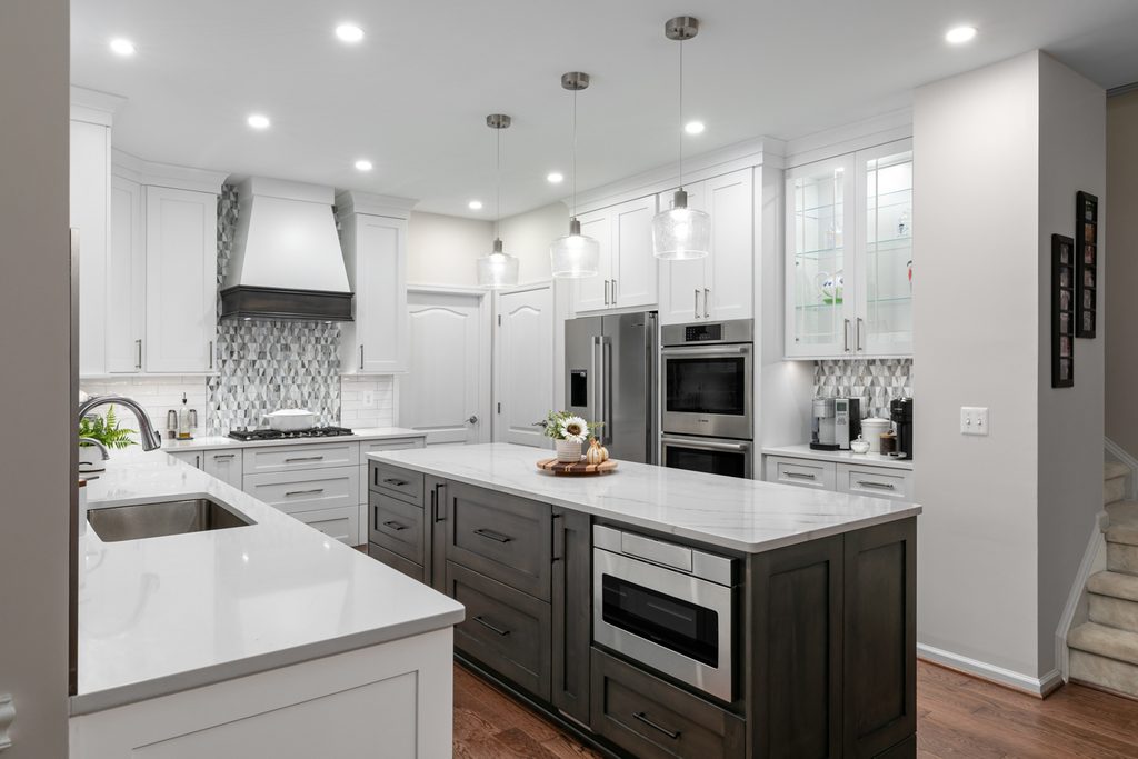 Graphite-stained maple kitchen island with white veined quartz top and three pendant lights