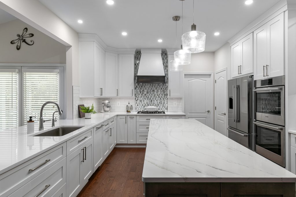 Graphite-stained maple kitchen island with white veined quartz top and three pendant lights