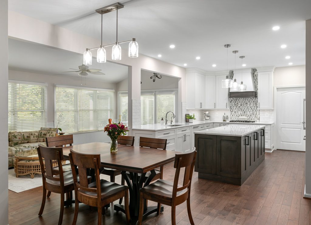 Soft-blue glass mosaic tile behind a gas cooktop in a gray and white kitchen