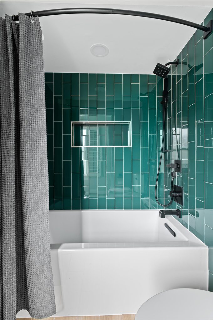 Eucalyptus green painted vanity with a quartz counter and flat black pulls