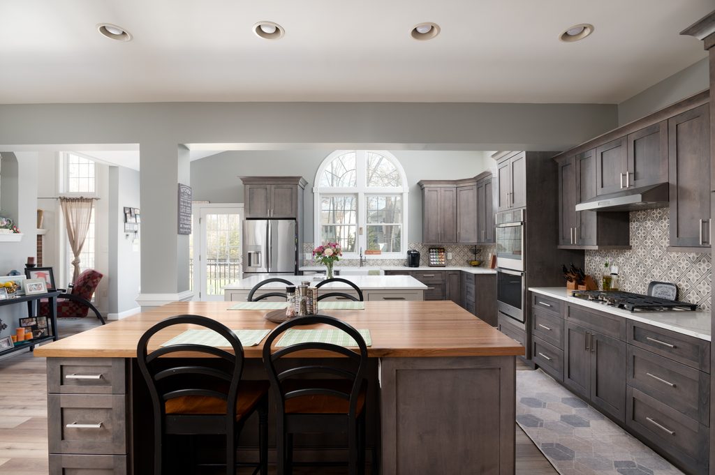 Kitchen with a painted gray prep island and a stained maple eat-on island beneath a vaulted ceiling in a Chantilly, Virginia home
