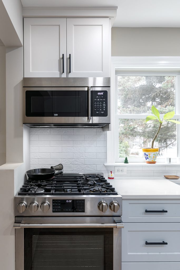 Textured backsplash tile in a half-offset pattern that reflects light in a bright kitchen