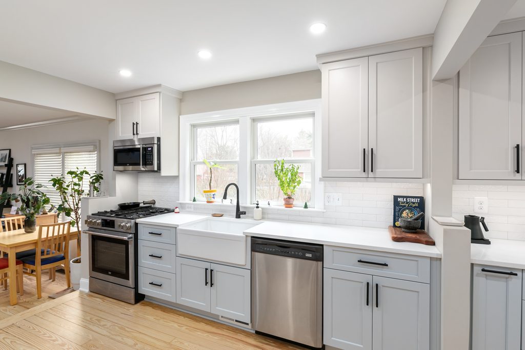 Dining room built-in with matching wood tops and a window-seat cabinet under a corner window