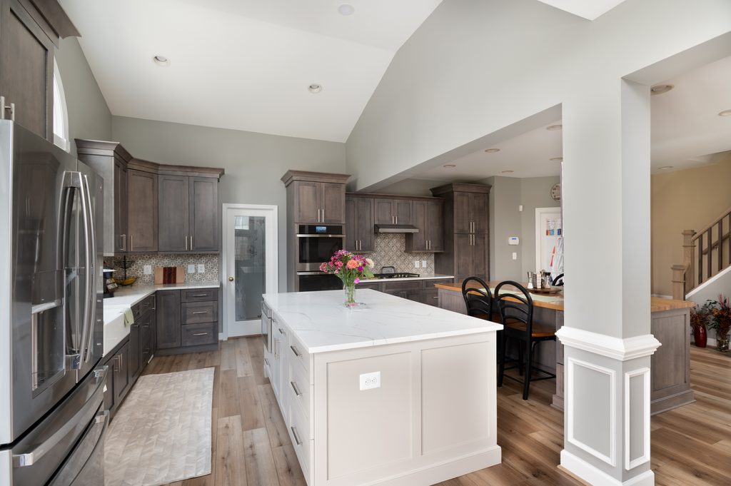 Matte charcoal porcelain backsplash behind a gas range and stainless double wall ovens