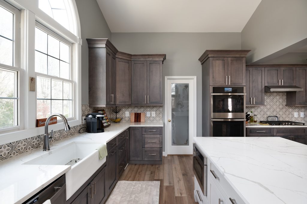 Walk-in pantry with a frosted glass door set into floor-to-ceiling cabinetry