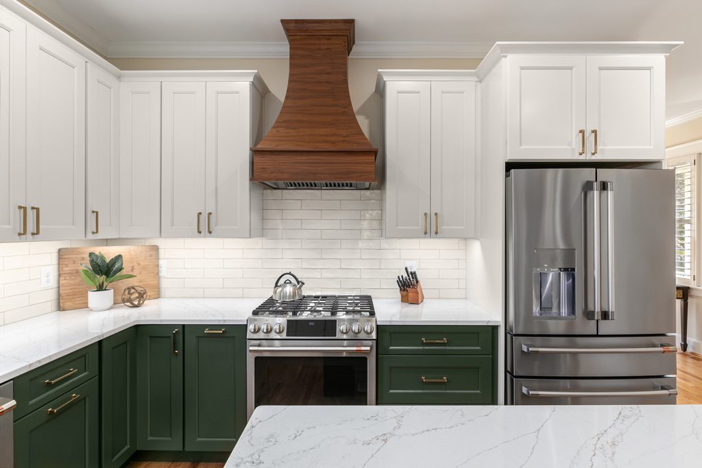 Walnut-stained range hood above a gas range with a classic subway tile backsplash