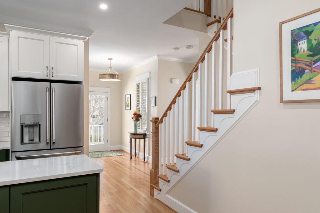 Foyer with natural oak stair treads, white risers, and turned oak newel posts