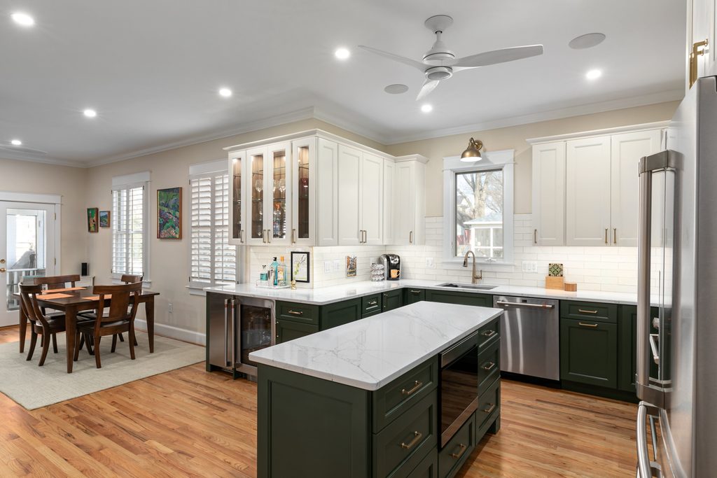 Deep green base cabinet with interior storage beside a gas range